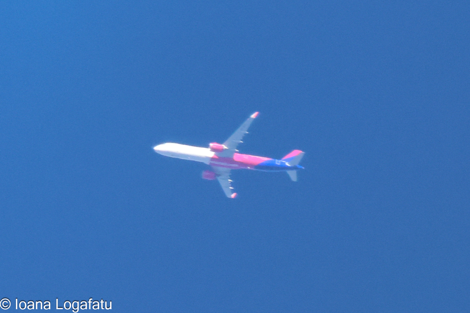 Airplane gliding through a clear blue sky above